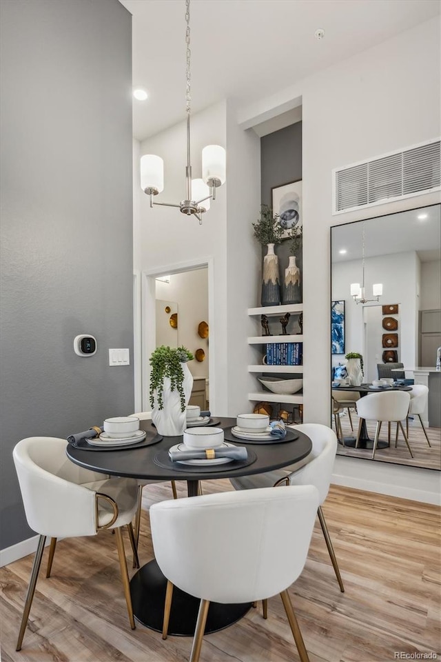487 Interlocken Blvd Unit 104, Broomfield, CO 80021 - dining area with a chandelier, wood finished floors, and a high ceiling