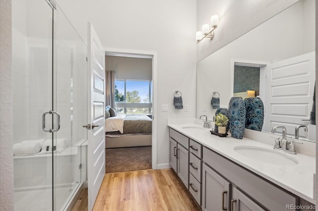 487 Interlocken Blvd Unit 104, Broomfield, CO 80021 - full bathroom featuring double vanity, wood finished floors, ensuite bathroom, a shower stall, and baseboards