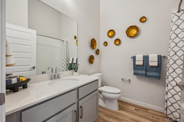 487 Interlocken Blvd Unit 104, Broomfield, CO 80021 - bathroom featuring vanity, wood finished floors, baseboards, toilet, and a shower with curtain