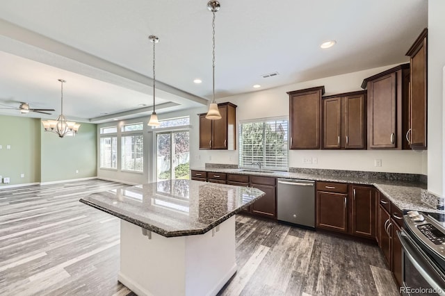 133 Poppy View Ln, Erie, CO 80516 - kitchen featuring stainless steel appliances, wood finished floors, a sink, dark stone counters, and dark brown cabinets