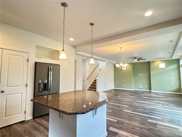 133 Poppy View Ln, Erie, CO 80516 - kitchen with stainless steel refrigerator with ice dispenser, dark wood-style flooring, a kitchen island, baseboards, and a kitchen breakfast bar