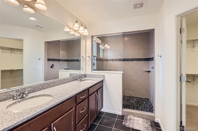 133 Poppy View Ln, Erie, CO 80516 - bathroom featuring double vanity, a spacious closet, a walk in shower, and tile patterned flooring