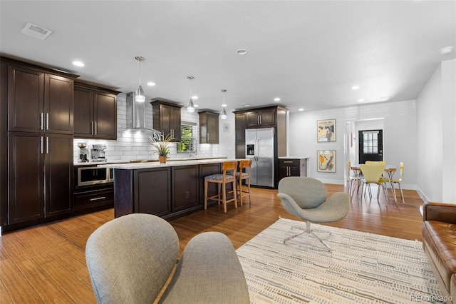 living room featuring light wood-type flooring, recessed lighting, and baseboards