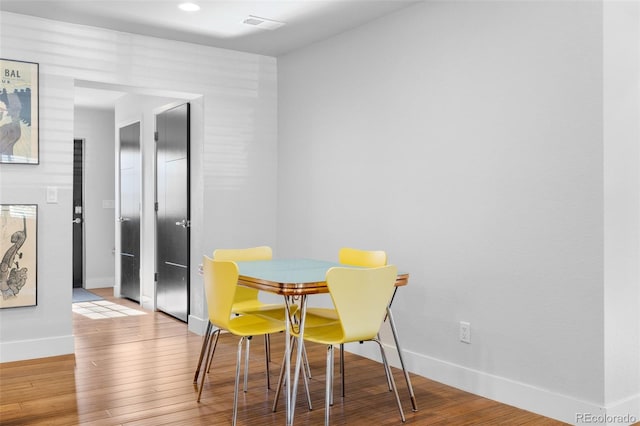 dining space featuring wood finished floors and baseboards