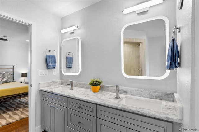 full bathroom featuring ensuite bathroom, double vanity, wood finished floors, and a shower