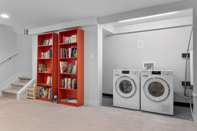 clothes washing area featuring separate washer and dryer, carpet flooring, and baseboards