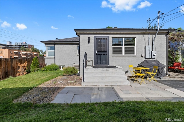 back of house featuring brick siding and a patio area