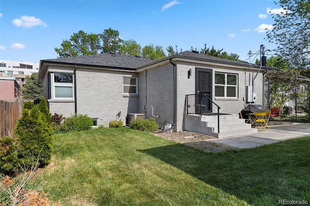 back of property with brick siding and central air condition unit