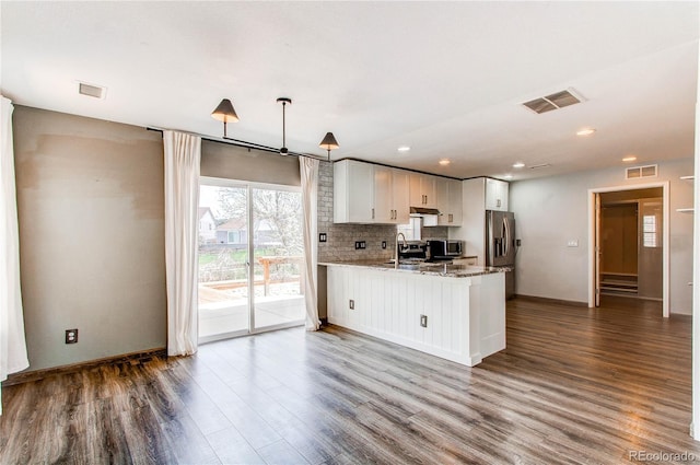 3607 Dinosaur St, Castle Rock, CO 80109 - kitchen featuring stainless steel appliances, dark wood finished floors, a peninsula, baseboards, and under cabinet range hood