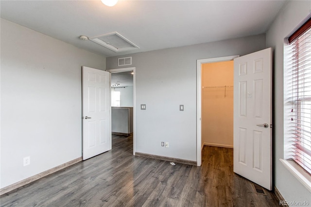 3607 Dinosaur St, Castle Rock, CO 80109 - unfurnished bedroom featuring wood finished floors, a walk in closet, baseboards, a closet, and attic access