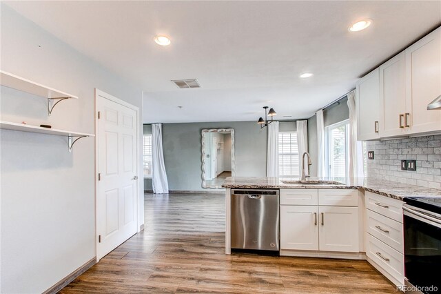 3607 Dinosaur St, Castle Rock, CO 80109 - kitchen featuring stainless steel appliances, a peninsula, white cabinets, recessed lighting, and decorative backsplash