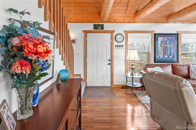 foyer entrance featuring hardwood / wood-style floors, beamed ceiling, and wooden ceiling