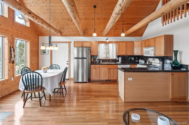 kitchen with hanging light fixtures, sink, high vaulted ceiling, light wood-type flooring, and white appliances