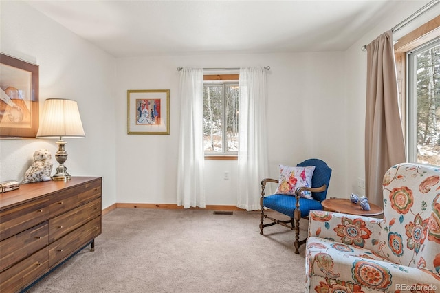 living area with a wealth of natural light and light colored carpet