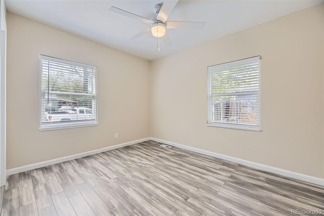 empty room featuring light wood finished floors and baseboards