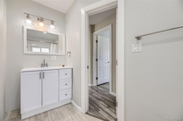 bathroom featuring wood finished floors, vanity, and baseboards