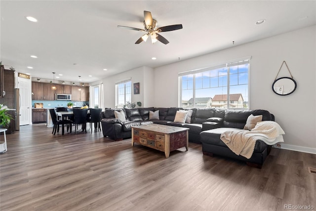 living area with recessed lighting, dark wood-style flooring, a ceiling fan, and baseboards