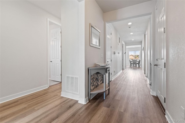 hallway with wood finished floors, baseboards, and recessed lighting