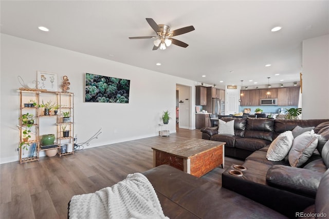 living area featuring a ceiling fan, recessed lighting, wood finished floors, and baseboards