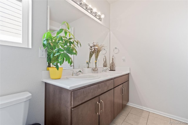 bathroom with tile patterned floors, toilet, and double vanity