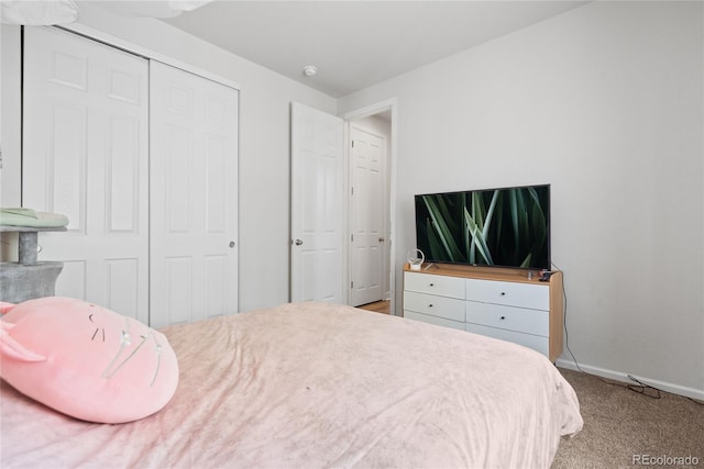 bedroom with carpet flooring, baseboards, and a closet