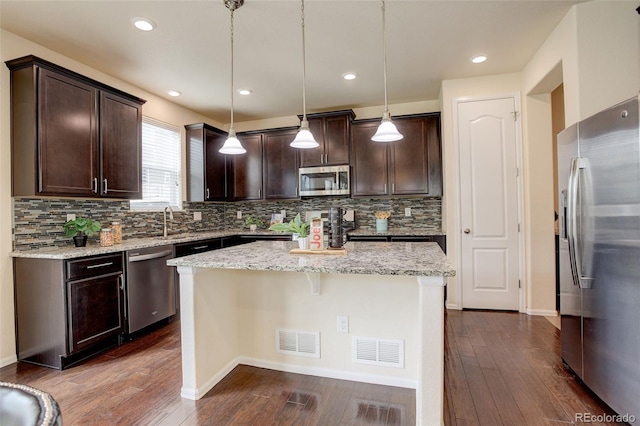 13351 Olive Way, Thornton, CO 80602 - kitchen featuring stainless steel appliances, dark brown cabinets, decorative backsplash, dark wood-style floors, and a center island
