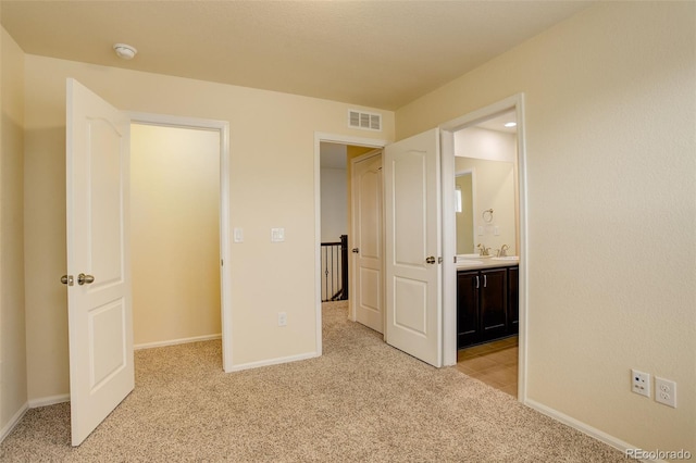 13351 Olive Way, Thornton, CO 80602 - unfurnished bedroom with light colored carpet, a sink, baseboards, and ensuite bath