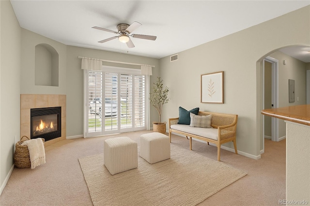 7440 S Blackhawk St Unit 104, Englewood, CO 80112 - carpeted living room featuring a ceiling fan, arched walkways, electric panel, and a tile fireplace
