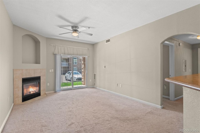 7440 S Blackhawk St Unit 104, Englewood, CO 80112 - unfurnished living room featuring ceiling fan, carpet, a fireplace, and arched walkways