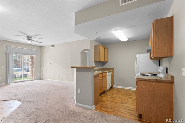 7440 S Blackhawk St Unit 104, Englewood, CO 80112 - kitchen with white appliances, a ceiling fan, open floor plan, brown cabinetry, and ventilation hood