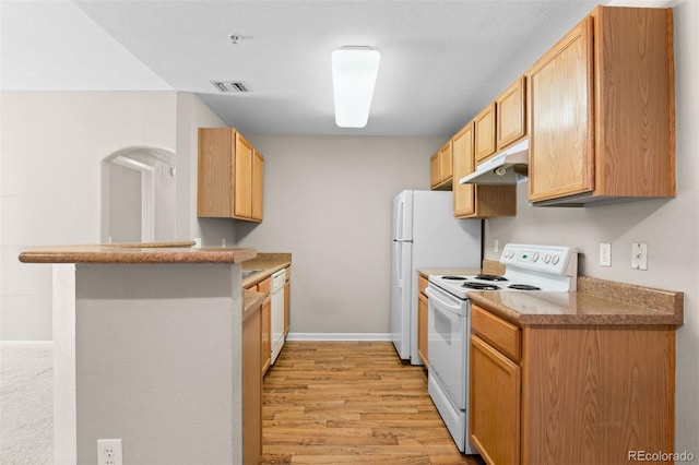 7440 S Blackhawk St Unit 104, Englewood, CO 80112 - kitchen with white appliances, under cabinet range hood, light wood finished floors, a peninsula, and light brown cabinets