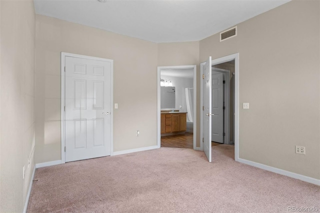 7440 S Blackhawk St Unit 104, Englewood, CO 80112 - unfurnished bedroom featuring light carpet and ensuite bath