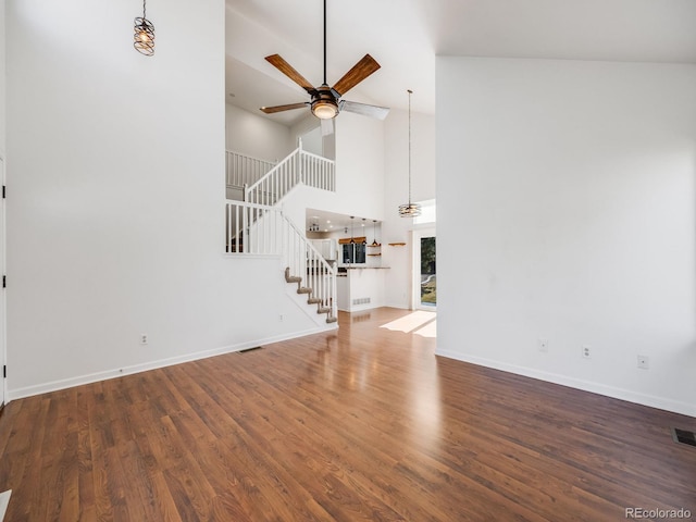 unfurnished living room featuring high vaulted ceiling, dark hardwood / wood-style floors, and ceiling fan