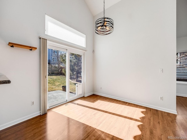 unfurnished room with hardwood / wood-style flooring and high vaulted ceiling