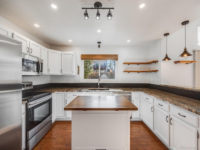 kitchen with appliances with stainless steel finishes, sink, white cabinets, and wood counters