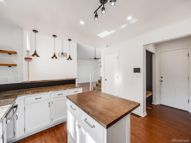 kitchen with white cabinetry, hanging light fixtures, stainless steel dishwasher, dark hardwood / wood-style floors, and kitchen peninsula