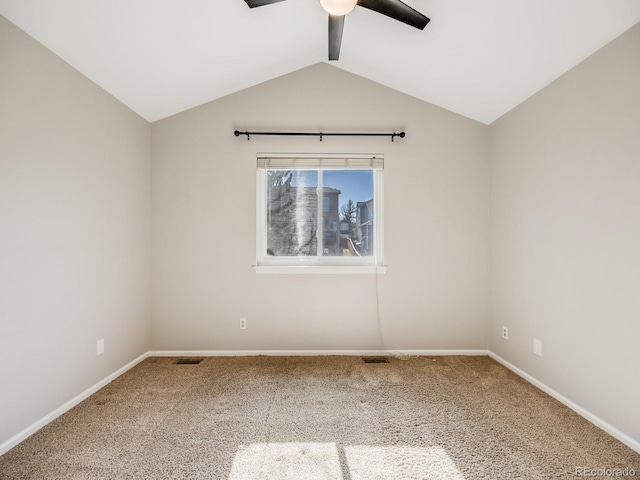 carpeted spare room with ceiling fan and vaulted ceiling