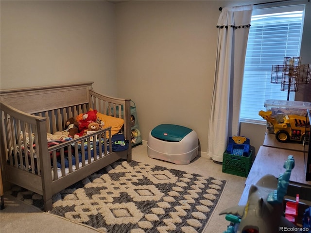 carpeted bedroom featuring a crib