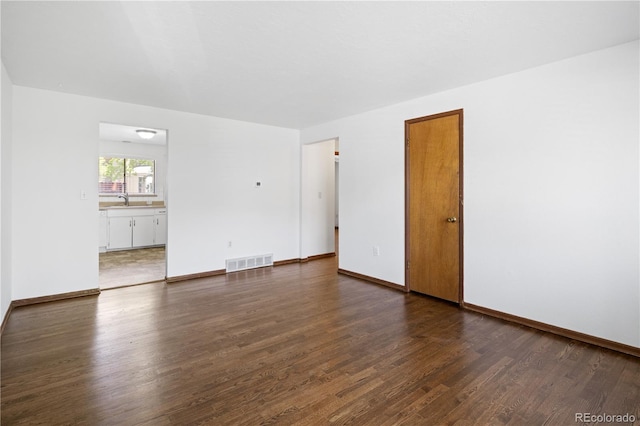 6004 S Prince St, Littleton, CO 80120 - spare room featuring dark wood-style floors, a sink, and baseboards