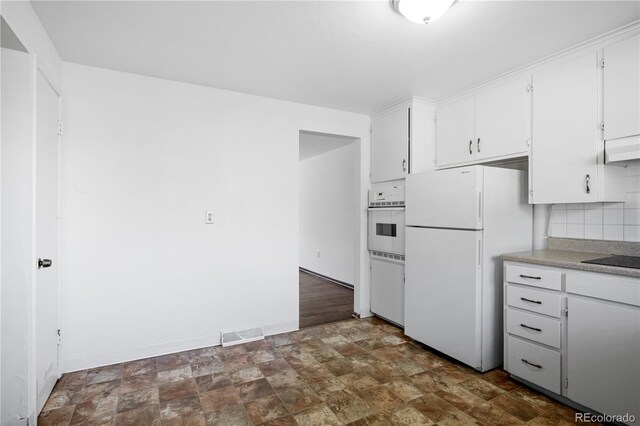 6004 S Prince St, Littleton, CO 80120 - kitchen featuring white appliances, stone finish floors, white cabinets, backsplash, and light countertops