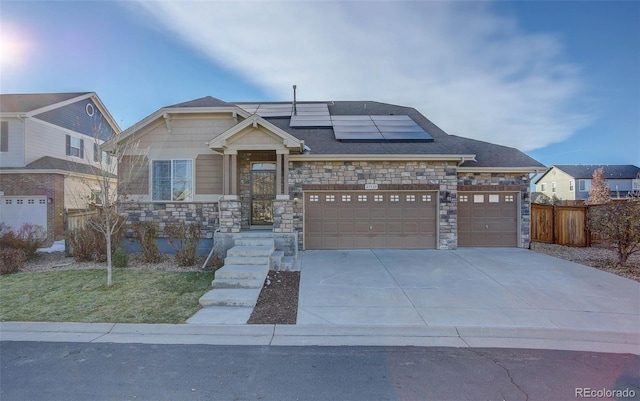 25525 E 1st Ave, Aurora, CO 80018 - view of front of home with stone siding, roof mounted solar panels, concrete driveway, and a garage