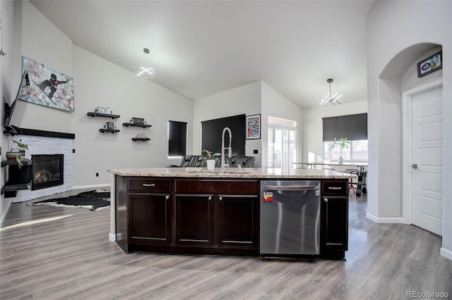 25525 E 1st Ave, Aurora, CO 80018 - kitchen with stainless steel dishwasher, light wood-style flooring, open floor plan, high vaulted ceiling, and light stone counters