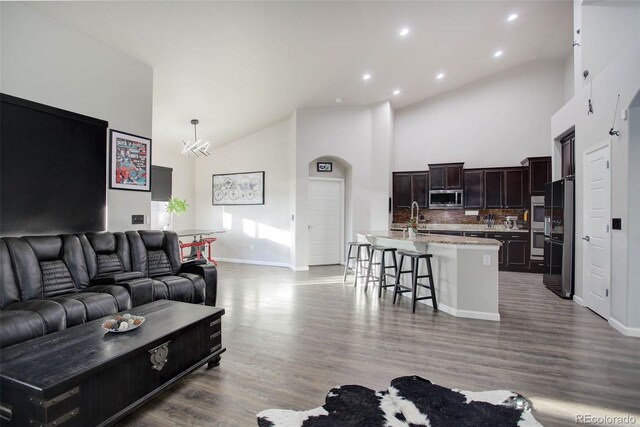 25525 E 1st Ave, Aurora, CO 80018 - living area featuring high vaulted ceiling, recessed lighting, and wood finished floors