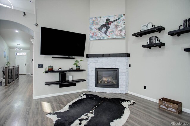 25525 E 1st Ave, Aurora, CO 80018 - living room with wood finished floors, a fireplace, and arched walkways