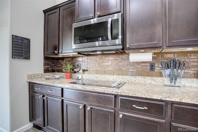 25525 E 1st Ave, Aurora, CO 80018 - kitchen featuring stainless steel microwave, dark brown cabinets, backsplash, and light stone countertops