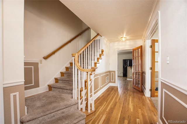 interior space featuring a textured ceiling, crown molding, and hardwood / wood-style floors