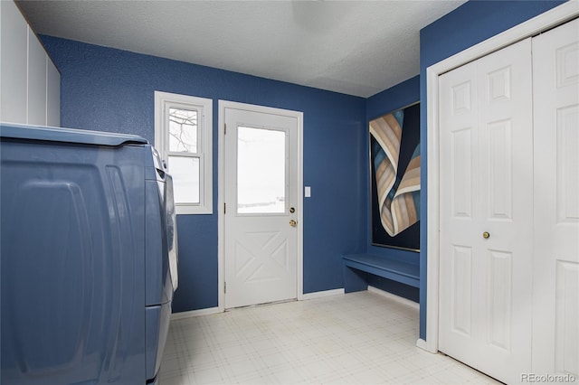 entryway with washer / clothes dryer and a textured ceiling