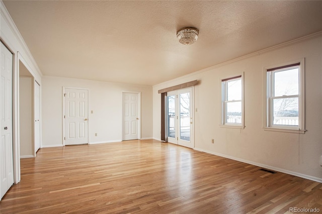 interior space featuring ornamental molding, a textured ceiling, and wood-type flooring