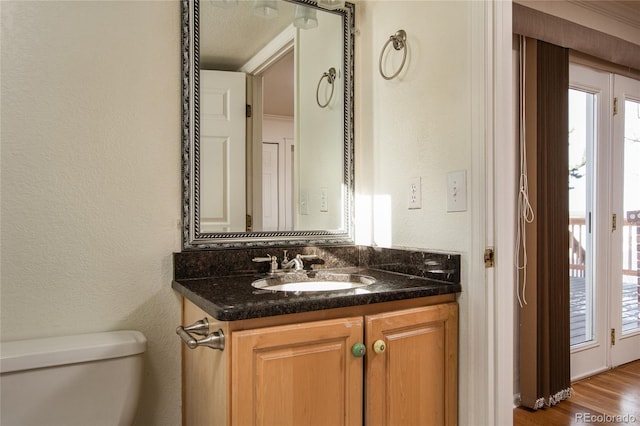 bathroom featuring toilet, wood-type flooring, and vanity