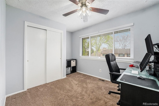 carpeted home office featuring visible vents, a ceiling fan, a textured ceiling, and baseboards
